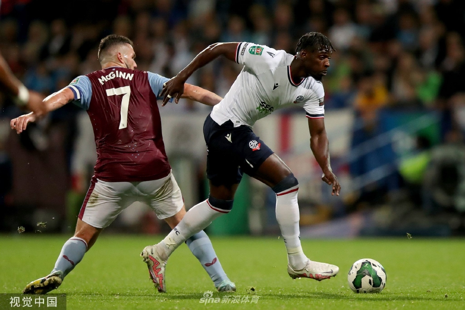 博尔顿前锋迪昂·查尔斯破门后张开双臂，在主场球迷的欢呼声中激情庆祝，他的队友正飞奔而来一同分享领先的喜悦。