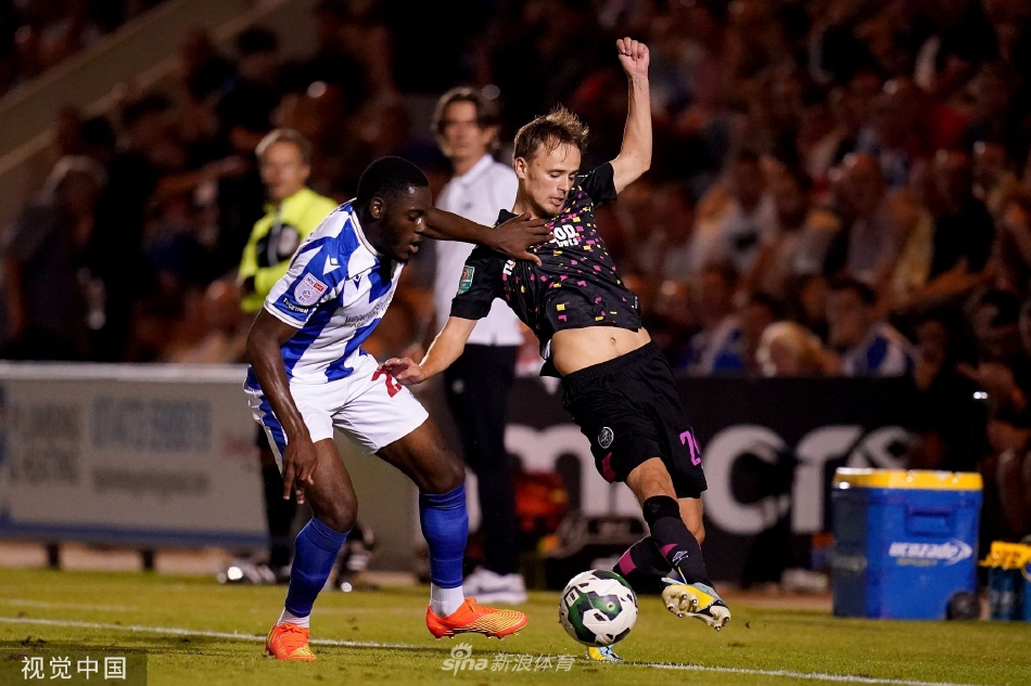 科切斯特联球员在边路强行突破，布伦特福德防守球员紧追不舍，两人在激烈的身体对抗中争夺球权。