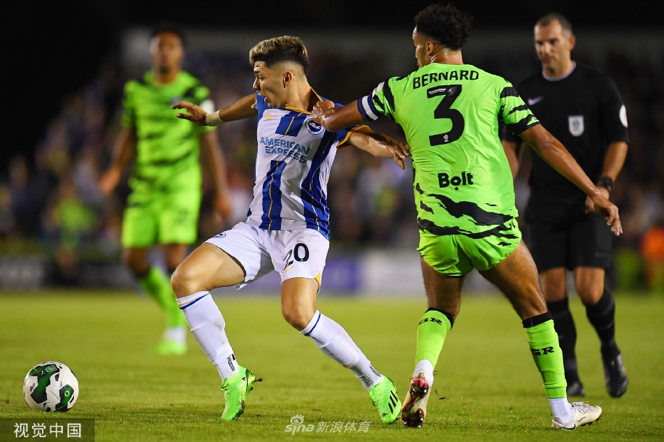 布莱顿球员在对方禁区前沿带球突破，两名防守球员形成包夹，攻防双方肌肉碰撞，场面紧张激烈。