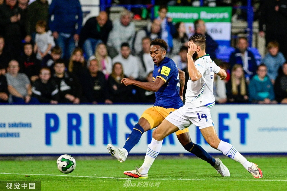 特兰米尔球员在中场附近与纽卡斯尔球员展开激烈拼抢，双方身体对抗激烈，表情专注，争夺球权。