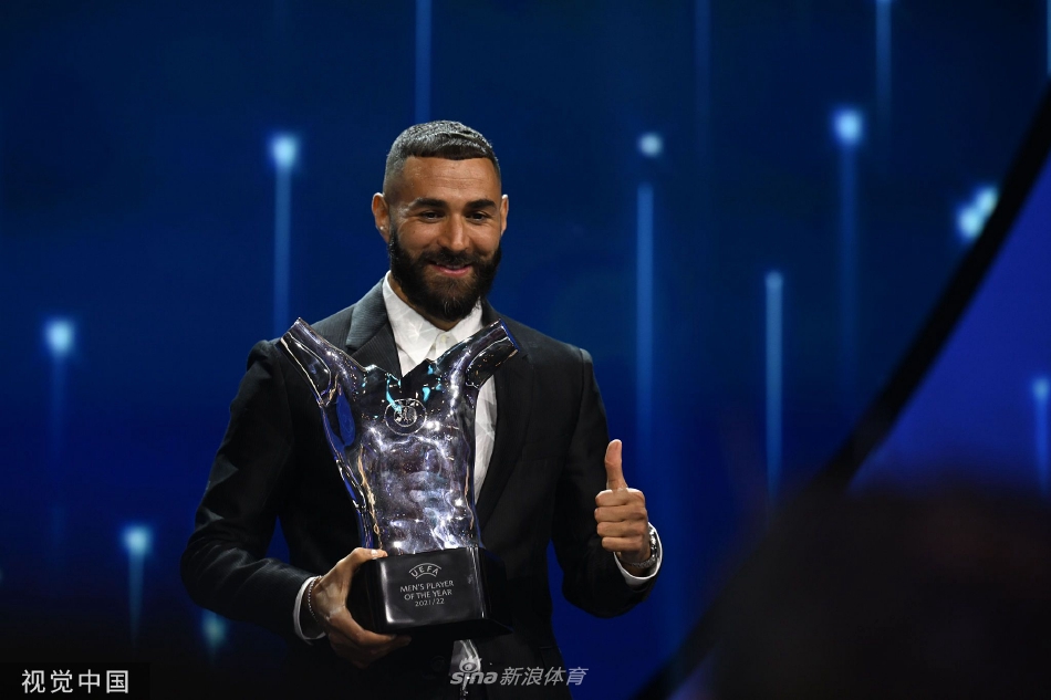 本泽马手持奖杯站在舞台中央发表获奖感言，台下坐着众多足坛名流与嘉宾，现场气氛隆重而热烈