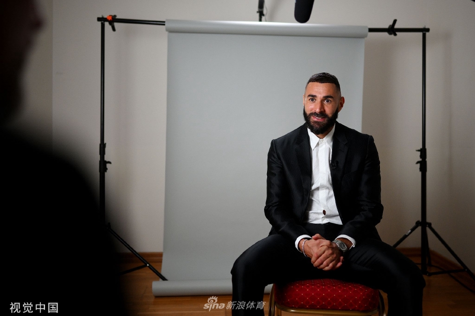 本泽马获奖后与欧足联主席切费林在背景板前亲切合影，双方手捧奖杯，共同记录这一荣耀瞬间