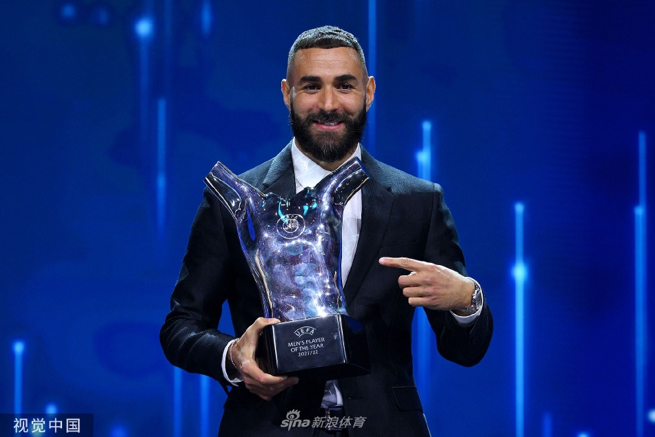 在颁奖典礼的聚光灯下，本泽马凝视手中的最佳球员奖杯，眼神中充满了成就、感慨与对未来的坚定