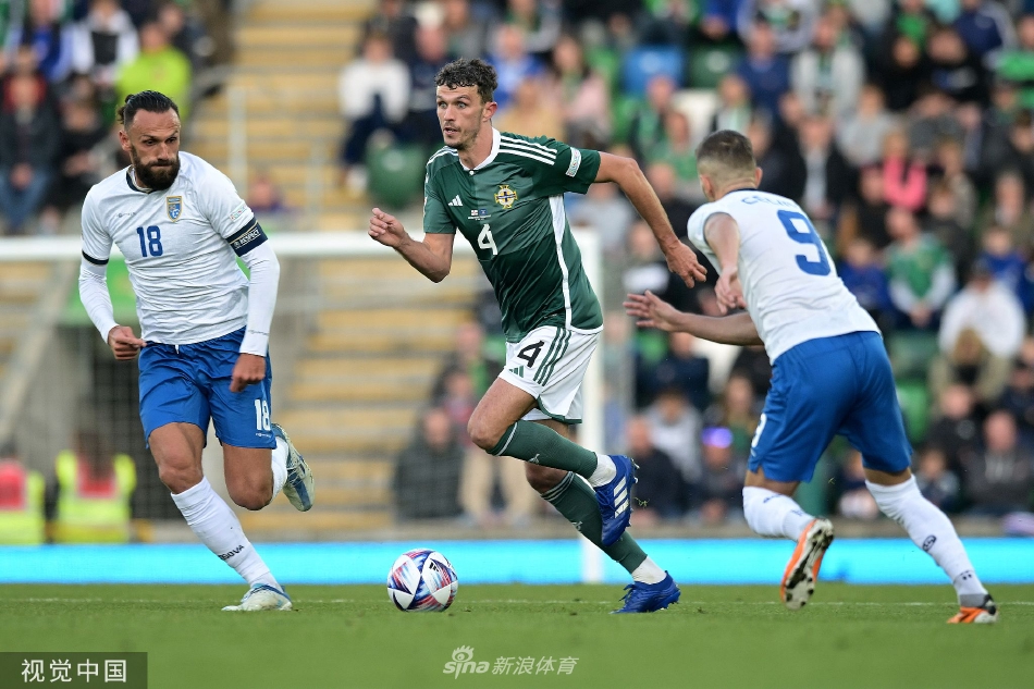 北爱尔兰球员在进球后激动地拥抱庆祝，他们手指向天，脸上洋溢着释放与狂喜的神情。