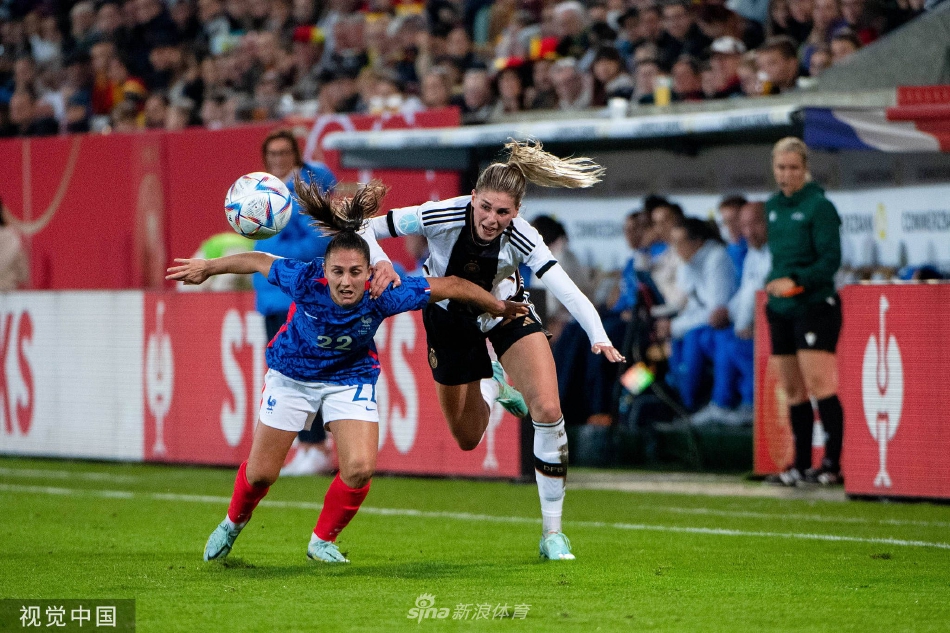 德国队与法国队球员在中场展开激烈的高空球权争夺，双方寸土不让，展现了高强度的比赛节奏。