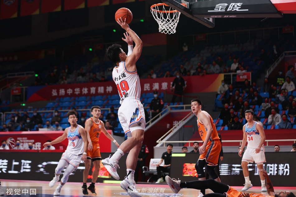 比赛结束后，新疆队球员们围成一圈，互相击掌鼓励，脸上洋溢着胜利的喜悦，团队士气高昂。