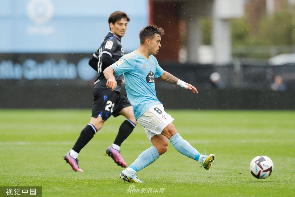 夜幕下的巴莱多斯球场全景，灯光如昼照亮绿茵，看台上球迷的身影与激烈的赛场构成一幅壮丽的足球画卷。