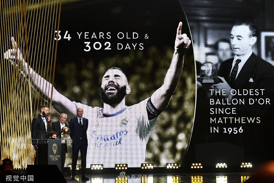 本泽马与金球奖合影，身后是深邃的星空背景，象征着他的成就已镌刻入足球历史的苍穹