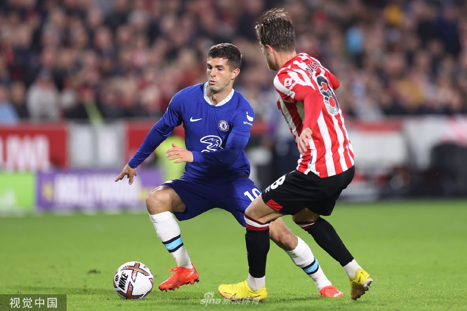 布伦特福德球员伊万·托尼在切尔西禁区前沿背身护球，身后两名蓝色防守球员寸步不离进行贴身盯防。