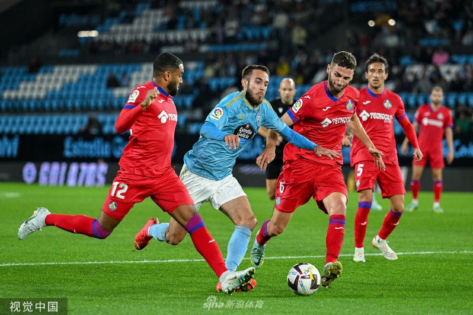 维戈塞尔塔球员激情滑跪庆祝进球，身后是疯狂涌来的队友，背景里赫塔菲球员垂首的身影与主场球迷的狂喜形成鲜明对比。