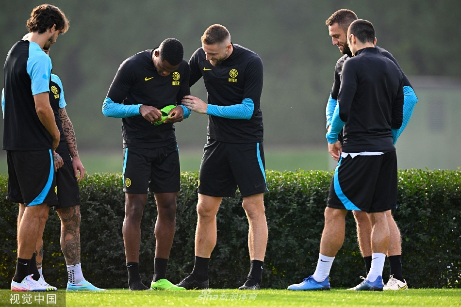 守门员在教练的指导下进行专注的扑救训练，身体完全舒展开来，指尖奋力触碰飞向死角的皮球。