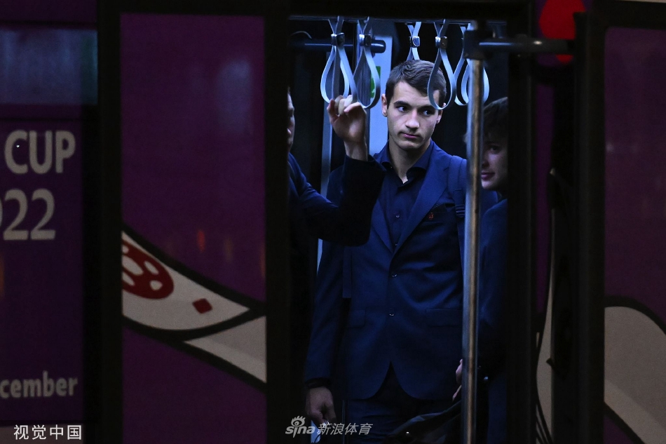 波兰队将士们走过机场通道，两侧玻璃幕墙映出他们挺拔的身影，阳光洒在肩头，仿佛为这支即将踏上战场的队伍披上了一层金色的战袍，充满了出征的仪式感。