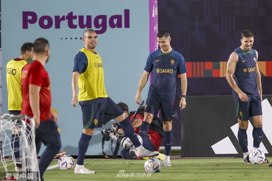 葡萄牙全队围成一圈进行战术部署，主教练桑托斯手持战术板神情专注，队员们凝神聆听