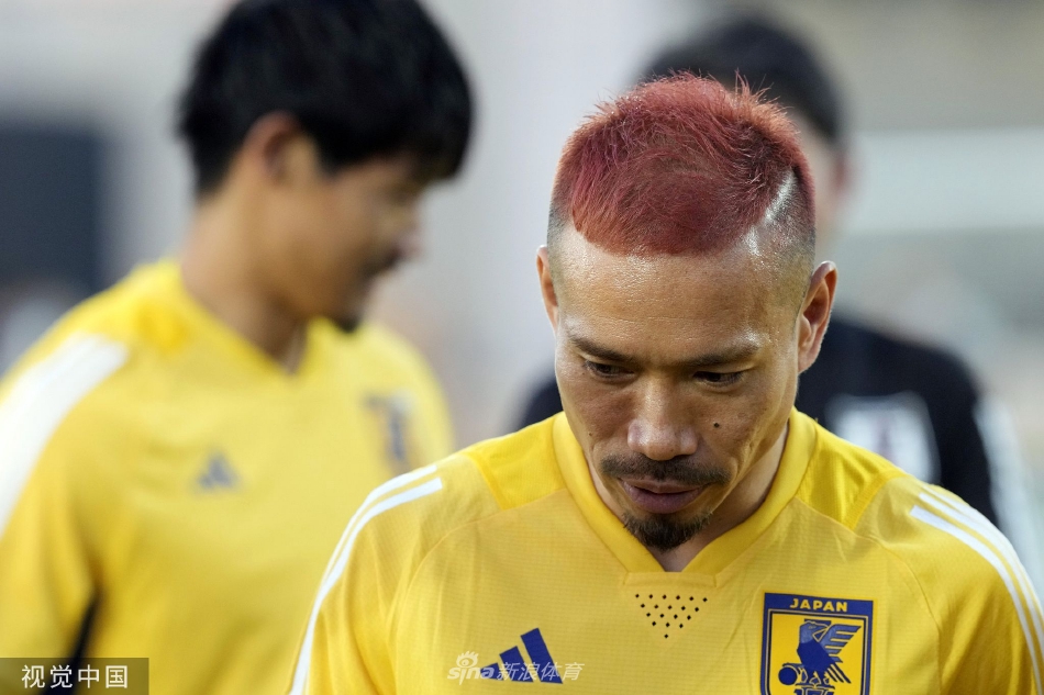 训练前的战术聚首：蓝武士围拢在主教练森保一身旁，聆听最后的战术部署，神情专注，战意凝聚于每一道目光交汇处。