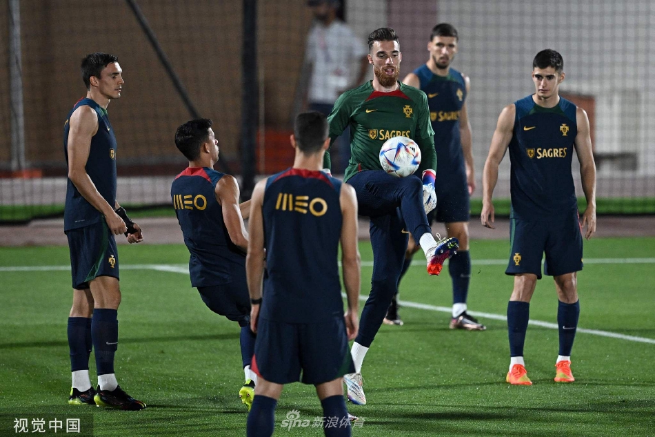 葡萄牙全队围成一圈聆听战术布置，桑托斯手持战术板神情严肃，球员们目光专注投射向教练