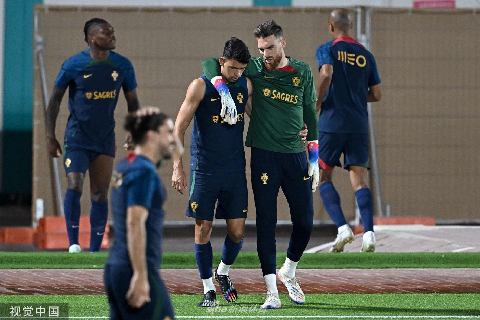 守门员在球门前飞身扑救，身体完全伸展如展翅雄鹰，指尖即将触碰到疾驰而来的足球