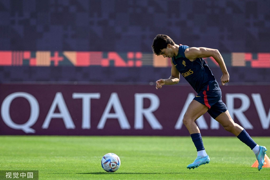 广角镜头下的训练全景，绿色草皮上点缀着身穿红色训练服的葡萄牙国脚们，构图充满动感与团队韵律