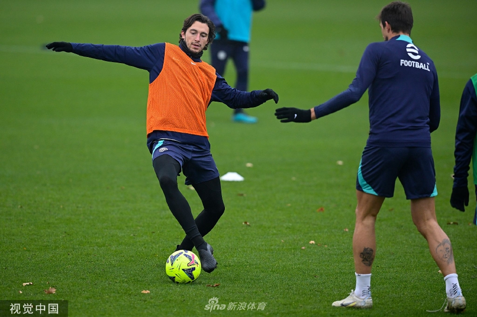 训练结束后，球员们带着足球离开场地，留下空旷而平整的绿色草坪