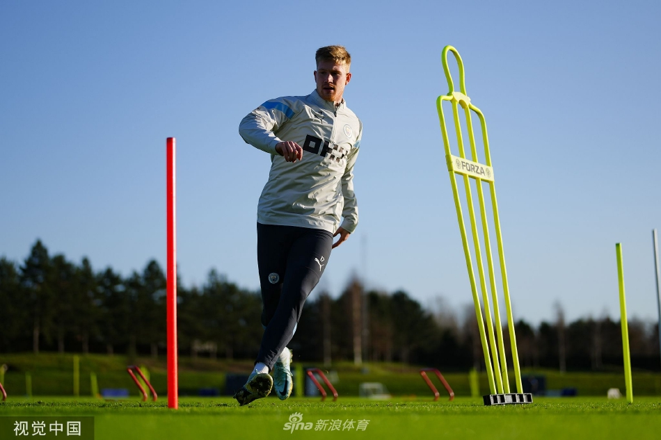 瓜迪奥拉与助理教练手持战术板进行深入交流，两人表情严肃，正在为如何破解对手防线做最后的战术部署。