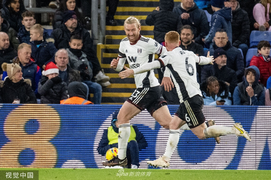 扎哈带球突破富勒姆两名防守队员的夹击，表情坚毅，肌肉线条分明，展现顶级边锋的冲击力。