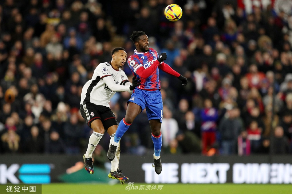 双方球员在中场进行激烈的高空球争顶，身体对抗激烈，目光紧盯着空中下落的足球。