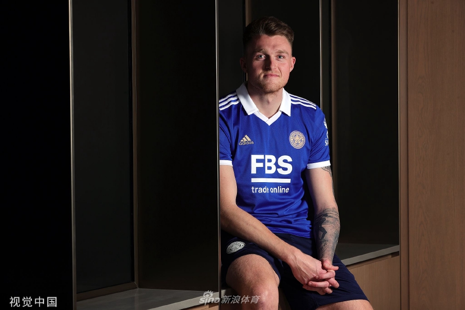 苏塔与俱乐部工作人员在训练基地内亲切交谈，背景是莱斯特城现代化的训练设施，预示着全新的开始。