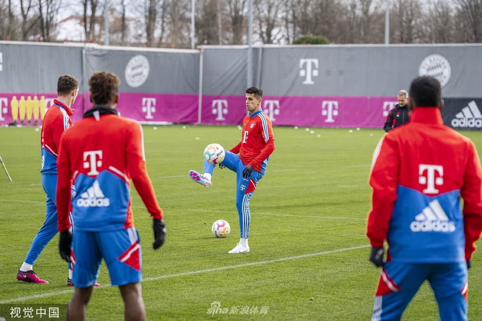 拜仁主帅纳格尔斯曼与助理教练在场边认真商讨战术，两人手持战术板，目光聚焦于训练场上的队员动态。