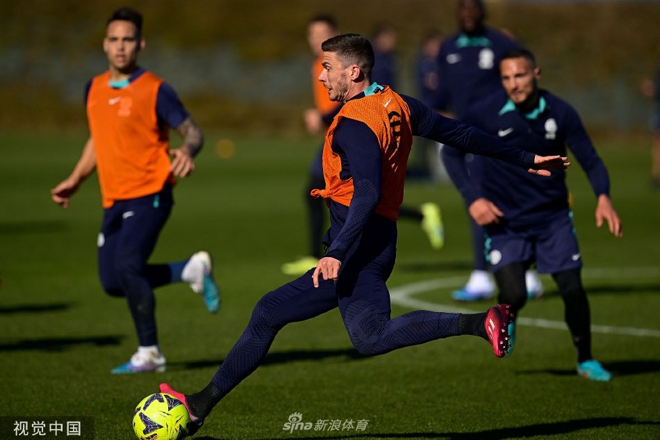 教练组成员在场边手持战术板，远远观察着球员们的分组对抗训练。