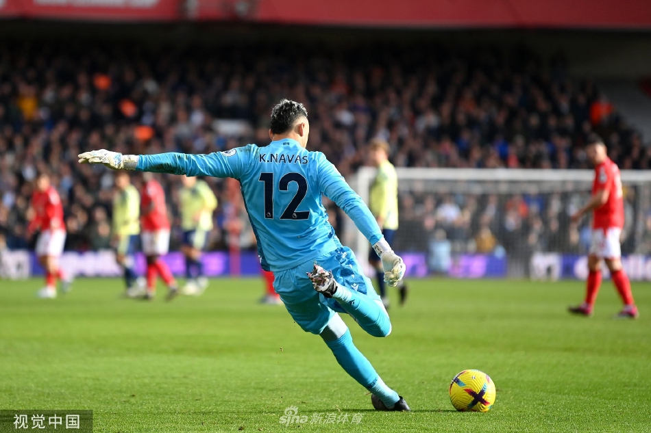 利兹联前锋在森林队两名后卫的包夹防守下艰难起脚射门，身体失去平衡，展现了客队进攻端遭遇的顽强阻力。