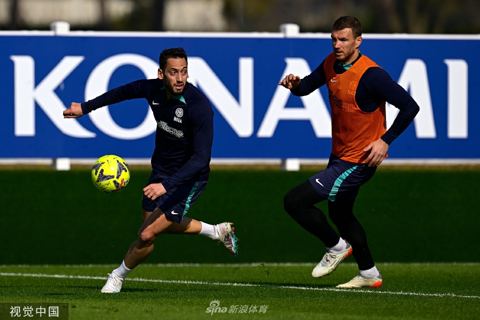 两名球员在教练指导下进行一对一攻防对抗，肌肉的碰撞与专注的表情体现了训练的实战化与高强度。