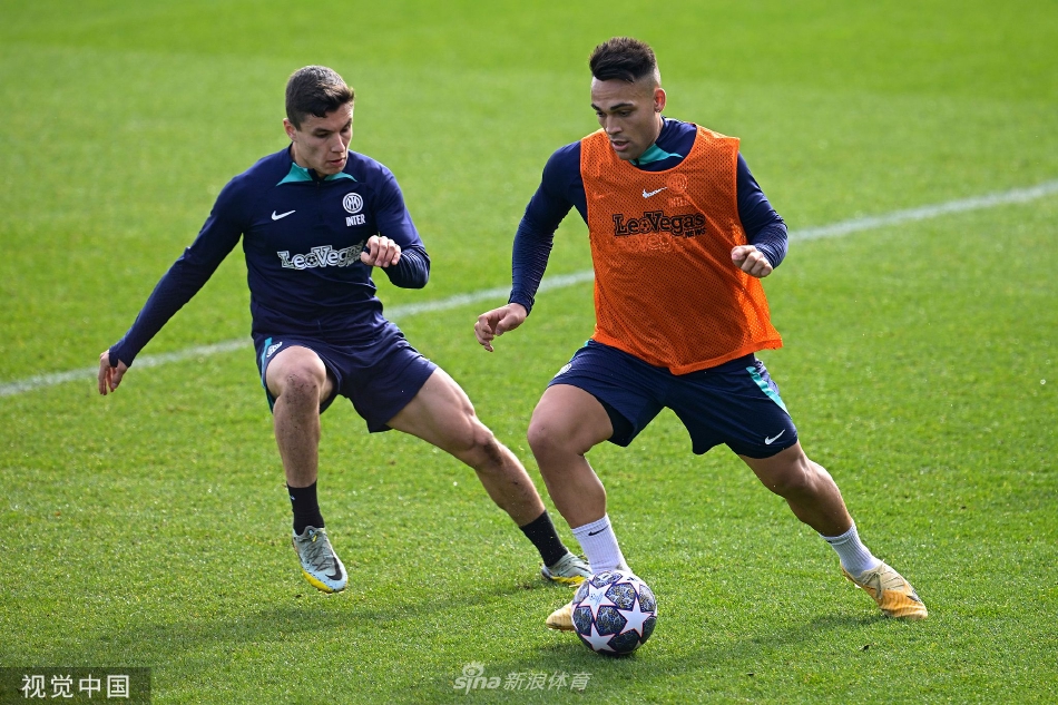 全队成员在训练结束后并肩站立进行总结，背景是科莫湖宁静的山水风光