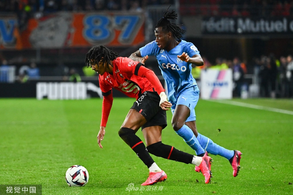 雷恩队球员主罚任意球，人墙高高跃起，皮球划出一道弧线越过人墙直飞球门死角，紧张氛围凝固在空气中