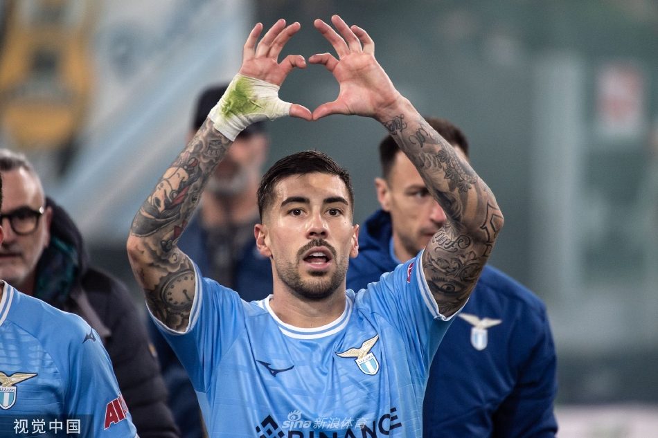 罗马门将帕特里西奥跪在门线前，神情懊恼地望向球网内的皮球，背景中拉齐奥球员庆祝的身影已模糊成一片欢腾的蓝。