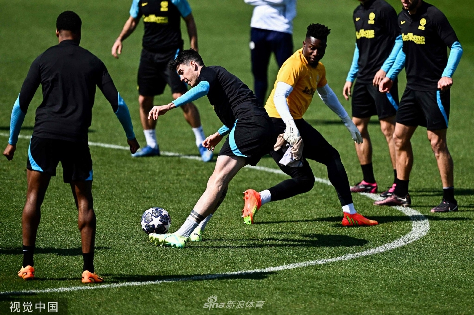 一名国际米兰后卫在对抗训练中高高跃起，力压进攻队员头球解围，展现出完美的制空能力与防守决心。