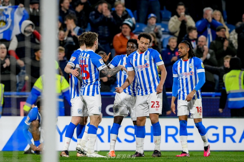 哈德斯菲尔德前锋在谢菲联后卫围堵下强行起脚射门，皮球如出膛炮弹般划破夜空，门将飞身扑救惊险万分。