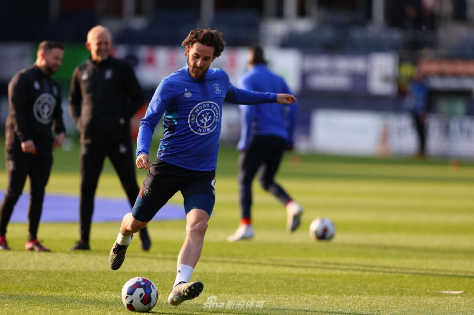 肯尼尔沃斯路球场看台一片沸腾，主场球迷身着橙色围巾，高举双臂汇成欢庆的海洋，气氛达到顶点。