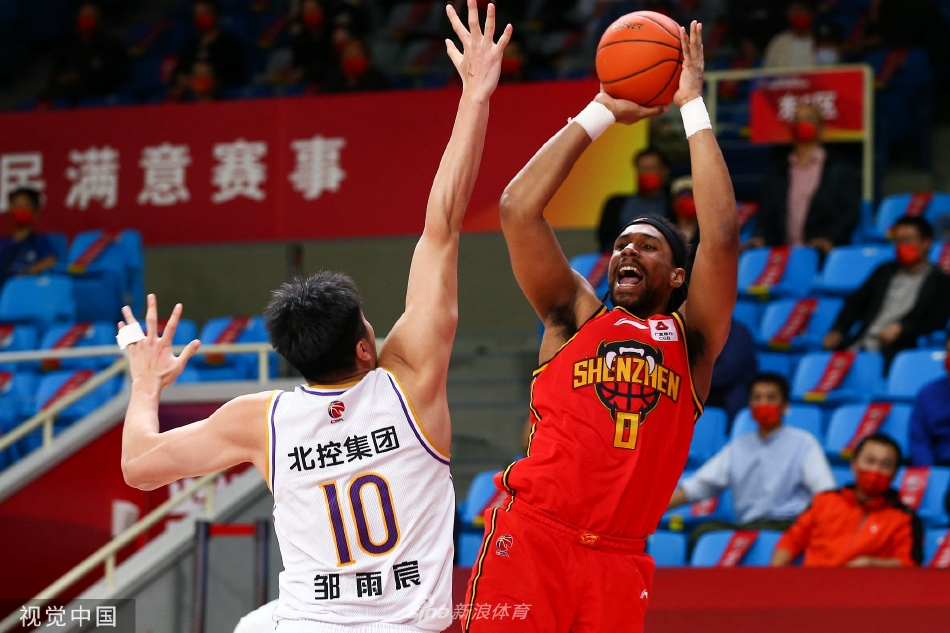 深圳外援布克强行突破上篮，北控内线球员跃起封盖，双方在空中形成激烈的攻防对决