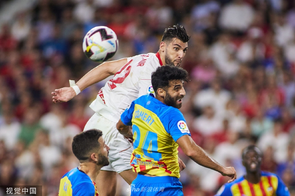 比赛结束后双方球员相互致意，背景是灯火通明的皮斯胡安球场