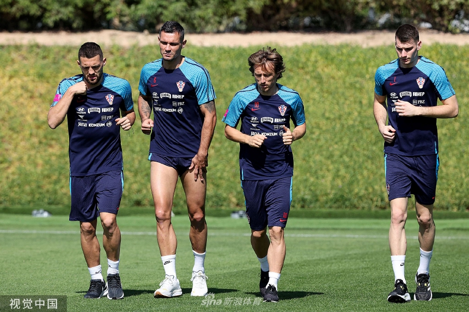 克罗地亚众将围聚聆听战术部署，红白战袍在绿茵上汇聚成团结的方格