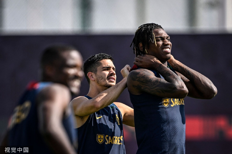 多哈训练场上，安德烈·席尔瓦面带微笑，正细心为身旁的拉斐尔·莱奥整理衣领，阳光将两人的身影拉长，气氛轻松而温暖