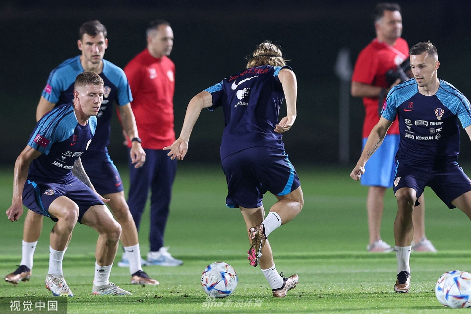 战术大脑的凝思时刻：主教练达利奇与教练组成员站在场边，手持战术板，神情严肃地讨论着训练细节，他们的目光如扫描仪般覆盖全场。