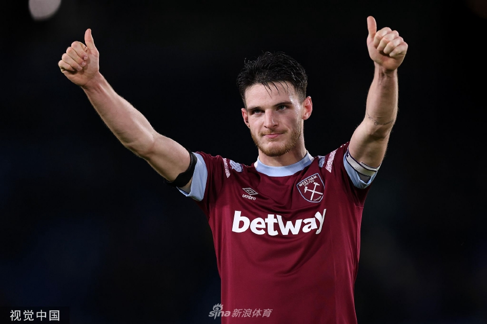 西汉姆联球员庆祝进球，他们紧紧相拥怒吼，背景是看台上失望的利兹联球迷，喜悦与失落形成鲜明对比。