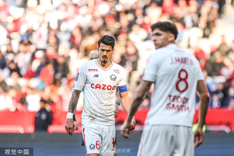 尼斯球员进球后张开双臂奔向角旗区激情庆祝，身后是欣喜若狂涌向看台边缘的忠实球迷，仿佛整个蔚蓝海岸都在为之震动。