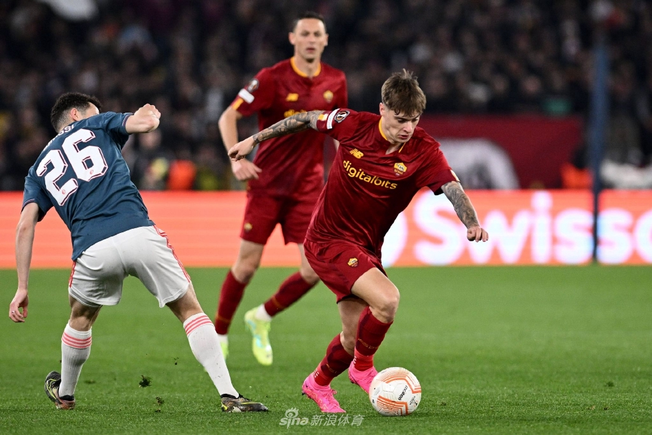 罗马队庆祝斯皮纳佐拉打破僵局的进球，球员们激情拥抱，看台上红色浪潮沸腾