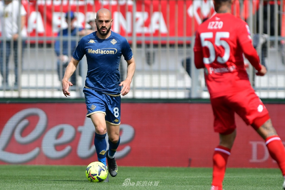 佛罗伦萨队球员萨波纳拉破门后滑跪庆祝，脸上写满兴奋，背景中蒙扎门将迪格雷戈里奥扑救未果，神情懊恼。