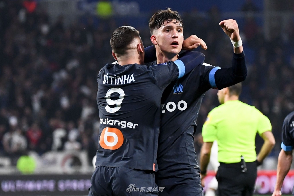 马赛后卫在禁区内严密盯防里昂进攻球员，双方身体对抗激烈，比赛充满张力。