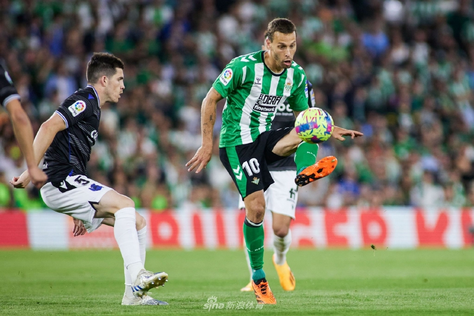 贝蒂斯前锋在对方后卫干扰下奋力起跳争顶头球，肌肉线条紧绷，展现了极强的空中对抗能力。