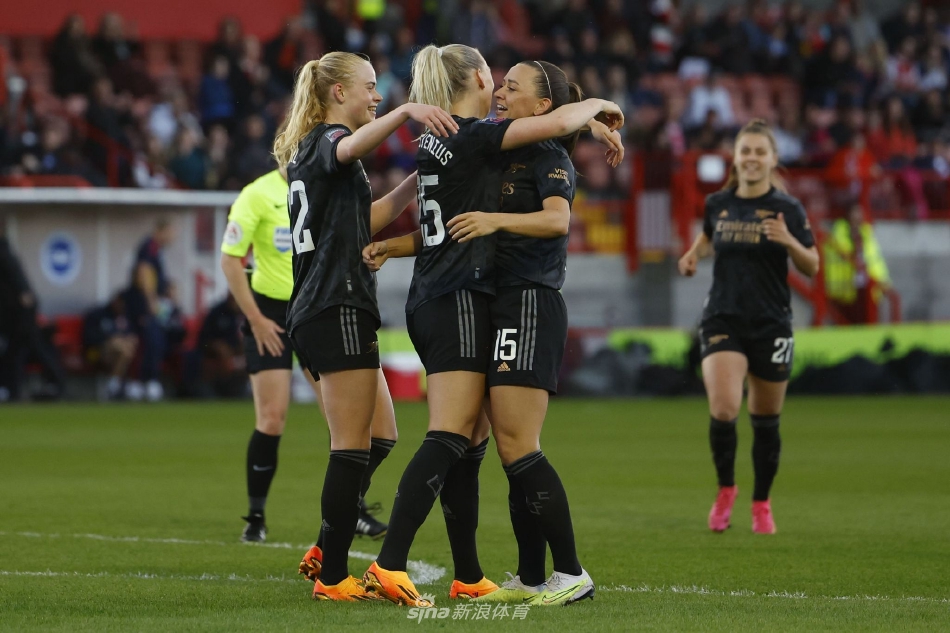 布莱顿女足球员在防守中奋力滑铲，试图拦截阿森纳球员的脚下球，草屑飞扬彰显比赛强度。