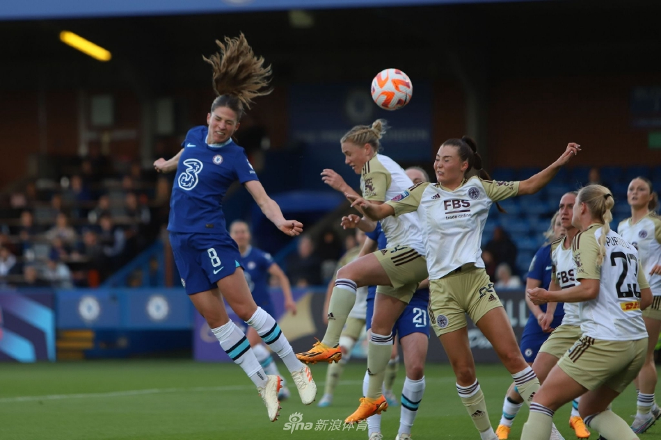 切尔西球员在角球进攻中高高跃起，力压防守队员头球攻门，身体在空中充分舒展，皮球划出强劲弧线飞向球门。