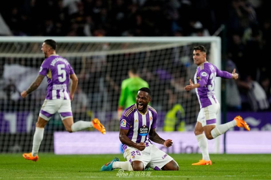 巴利亚多利德前锋贡萨洛·普拉塔带球突破巴萨防线，主场球迷在他身后形成一片沸腾的紫色海洋